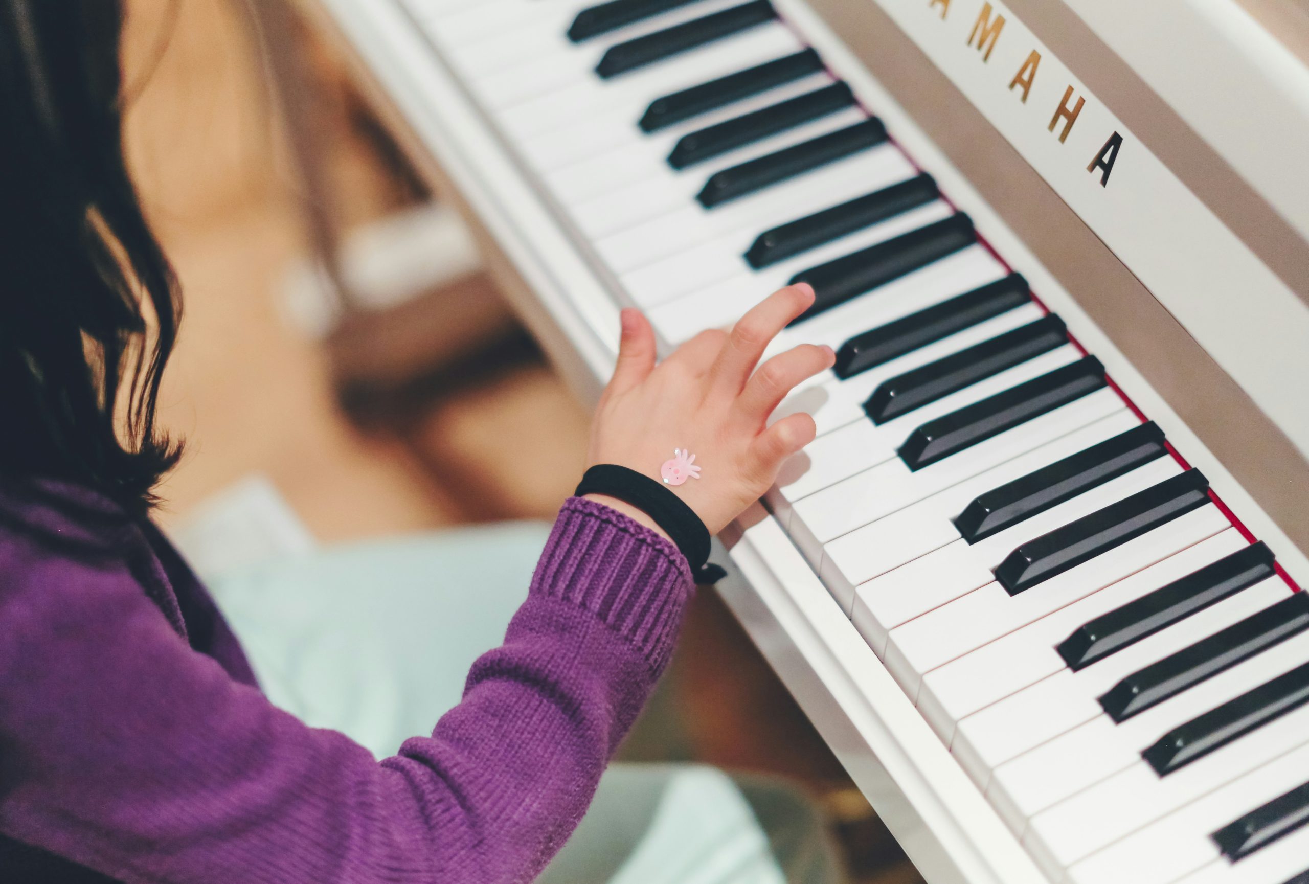 Kind speelt piano in natuurlijke thuisomgeving tijdens muziekles